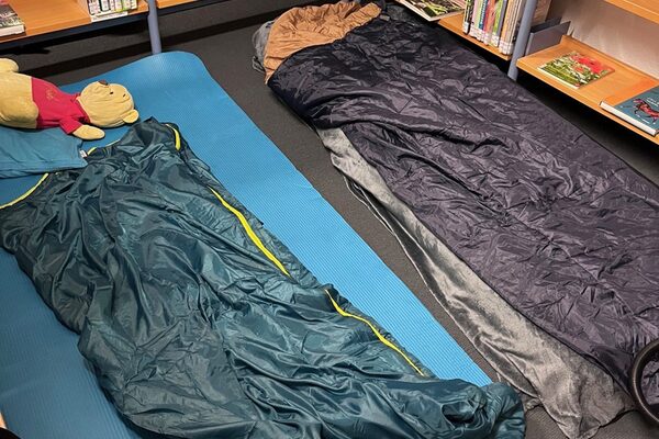 Isomatten und Schlafsäcke zwischen Bücherregalen