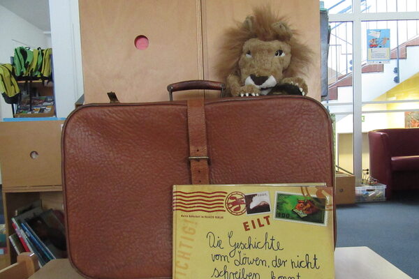 Koffer mit Löwe und Buch